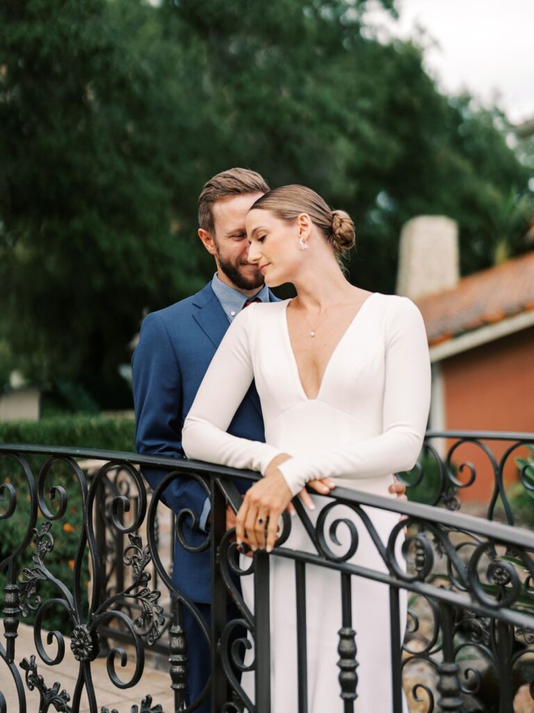 A bride and groom embrace on a bridge at the Westlake Village Inn during their weekday wedding in California.